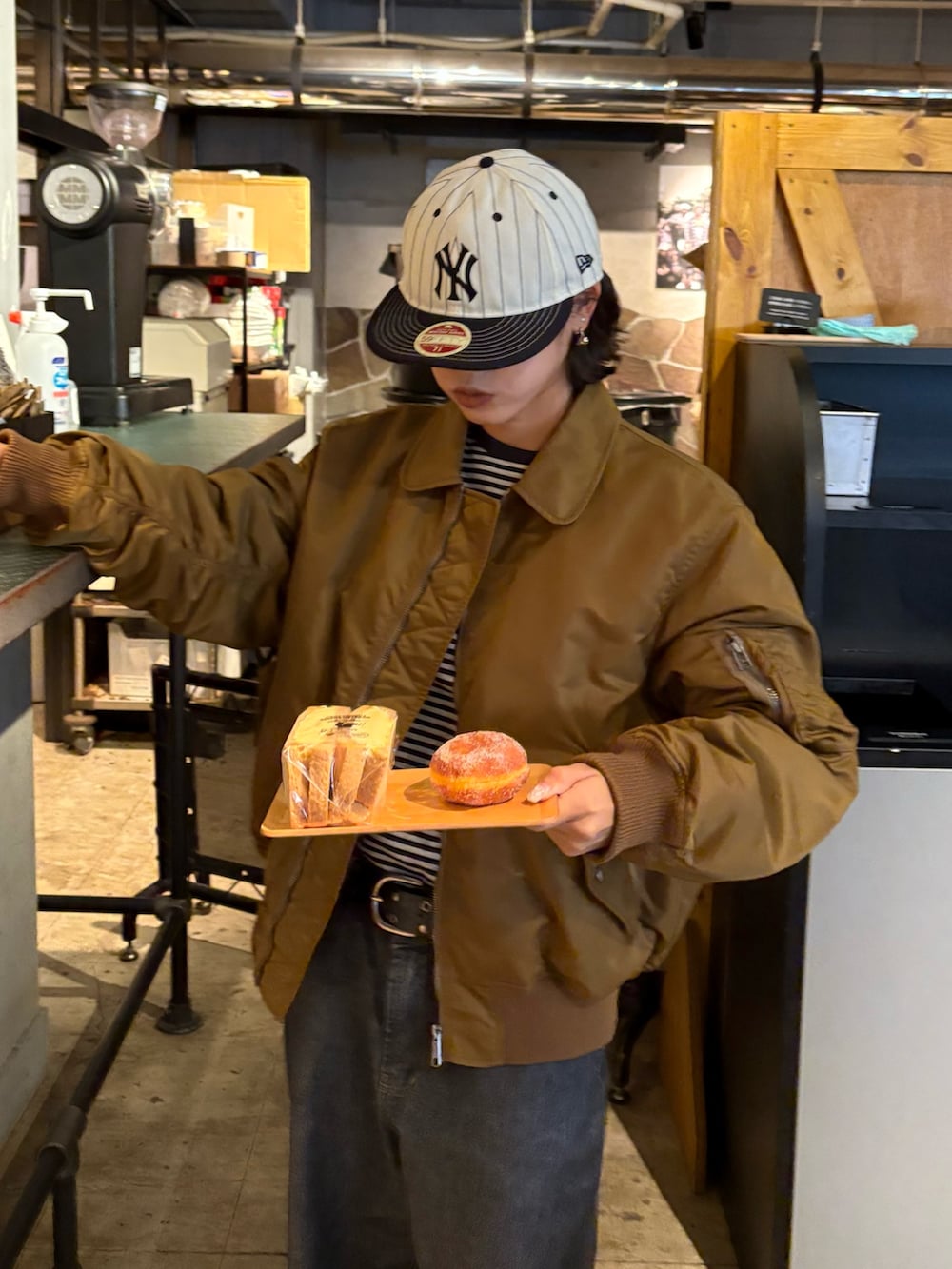 イエロー系のMA-1、ブラック系のトートバッグを着用したレディースの秋コーディネートの2枚目の写真