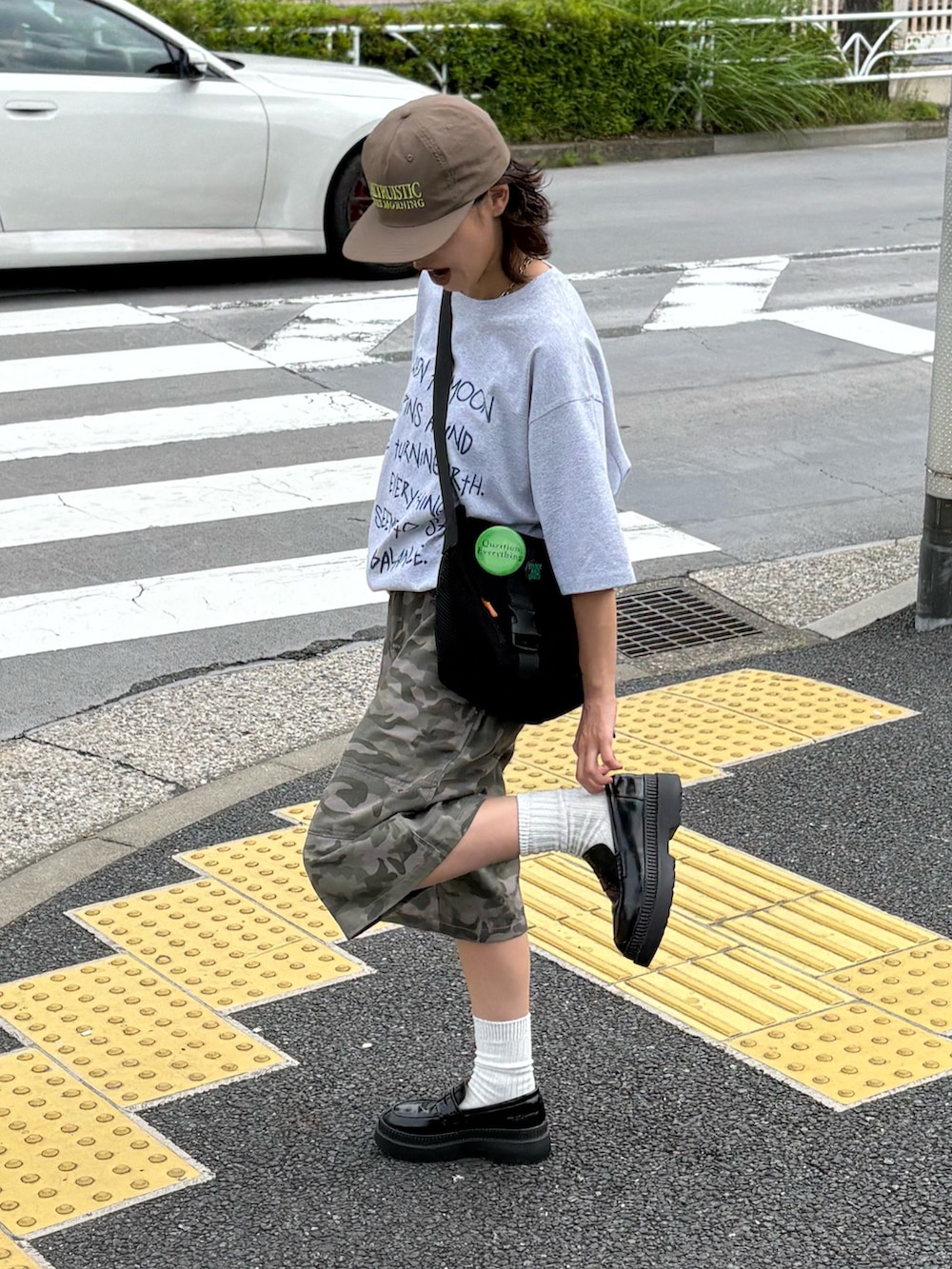グレー系のTシャツ/カットソー、グリーン系のその他パンツ、ブラック系のショルダーバッグを着用したレディースの春コーディネートの2枚目の写真