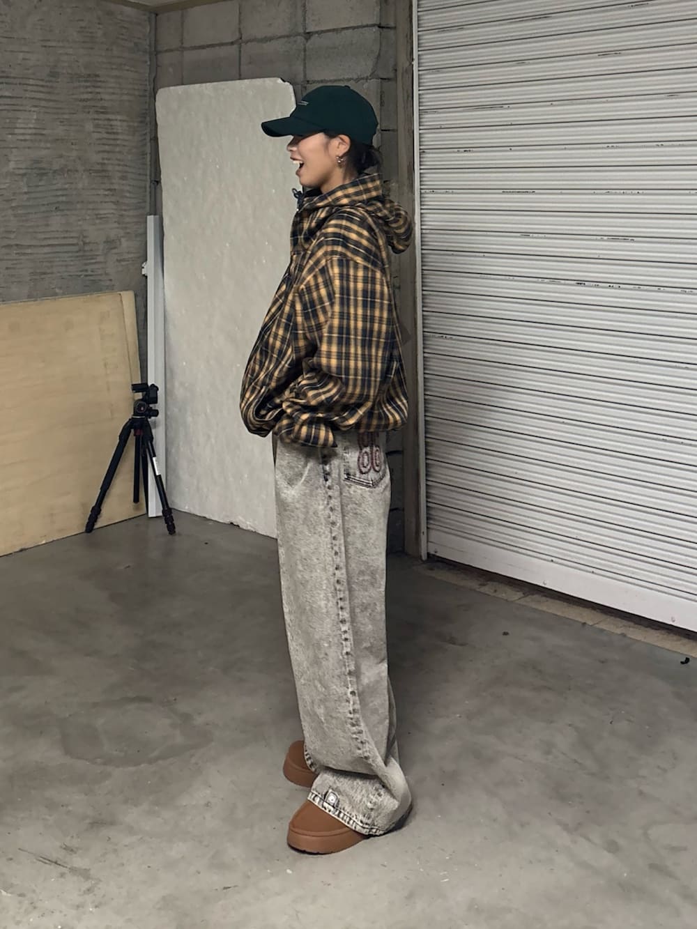 ブラック系のデニムパンツ、ブラウン系のサンダル、イエロー系のブルゾンを着用したレディースの冬コーディネートの3枚目の写真