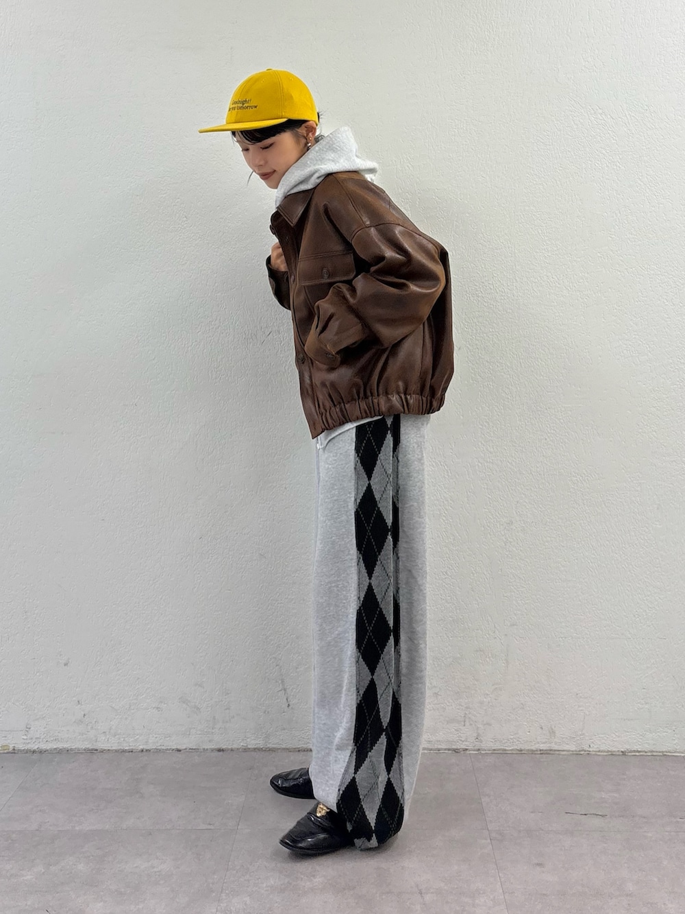 ブラウン系のブルゾン、ブルー系のその他パンツ、グレー系のパーカーを着用したレディースの秋コーディネートの2枚目の写真