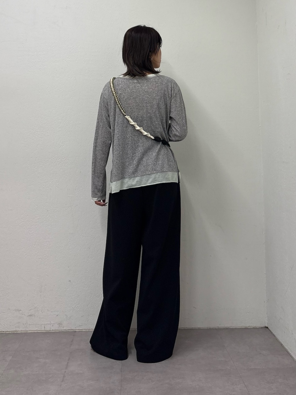 グレー系のTシャツ/カットソー、ブラック系のスラックス、シルバー系のスニーカーを着用したレディースの冬コーディネートの3枚目の写真