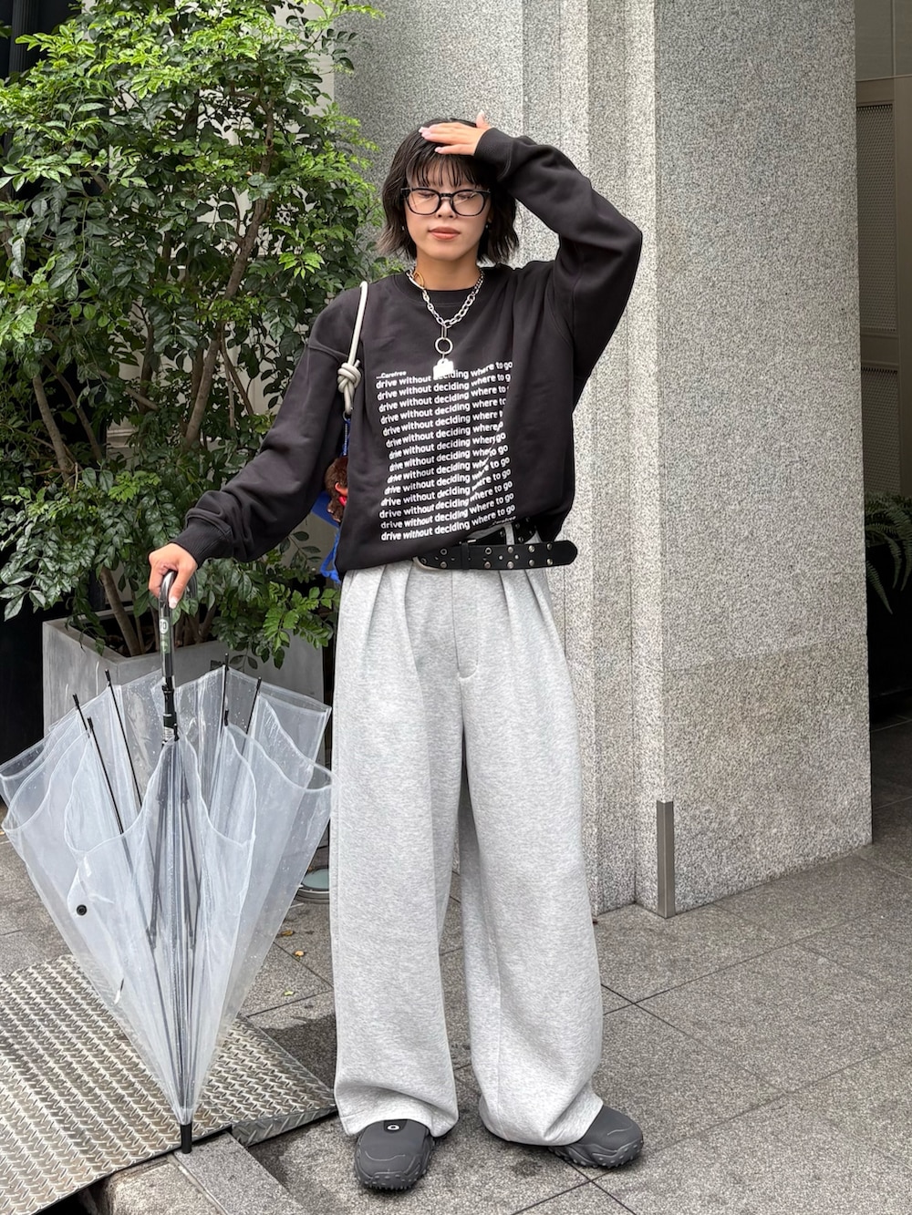 ブラック系のスウェット、グレー系のその他パンツ、ブルー系のショルダーバッグを着用したレディースの秋コーディネートの2枚目の写真