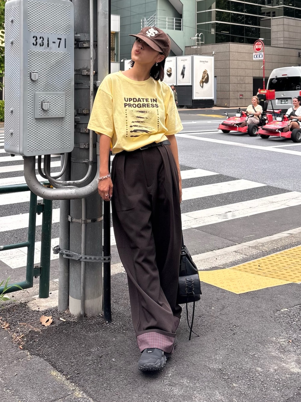 イエロー系のTシャツ/カットソー、ブラウン系のその他パンツ、ブラック系のショルダーバッグを着用したレディースの秋コーディネートの2枚目の写真