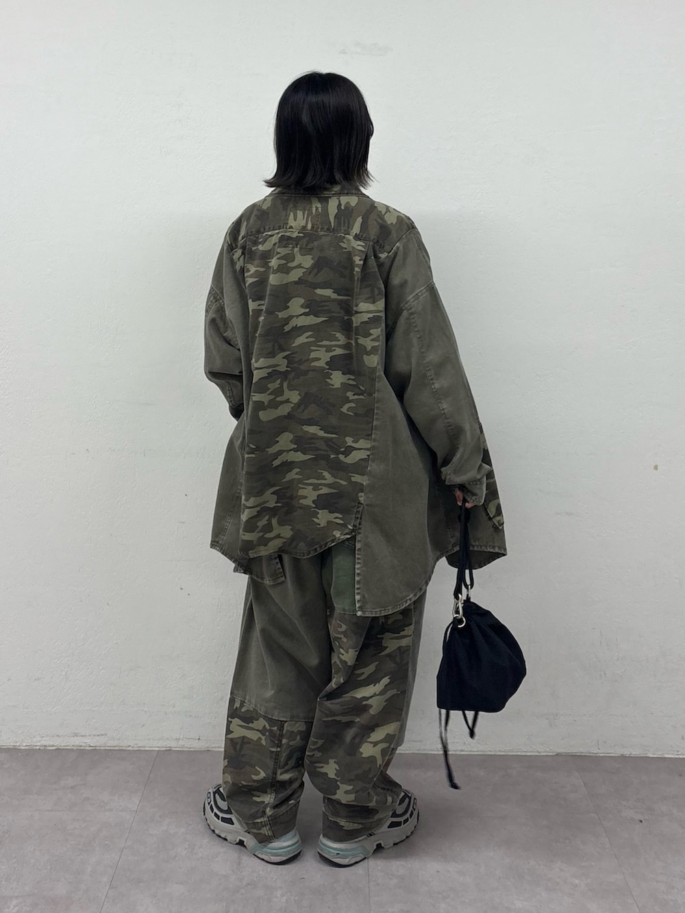 グリーン系のブルゾン、ブラック系のスウェット、ホワイト系のTシャツ/カットソーを着用したレディースの秋コーディネートの3枚目の写真