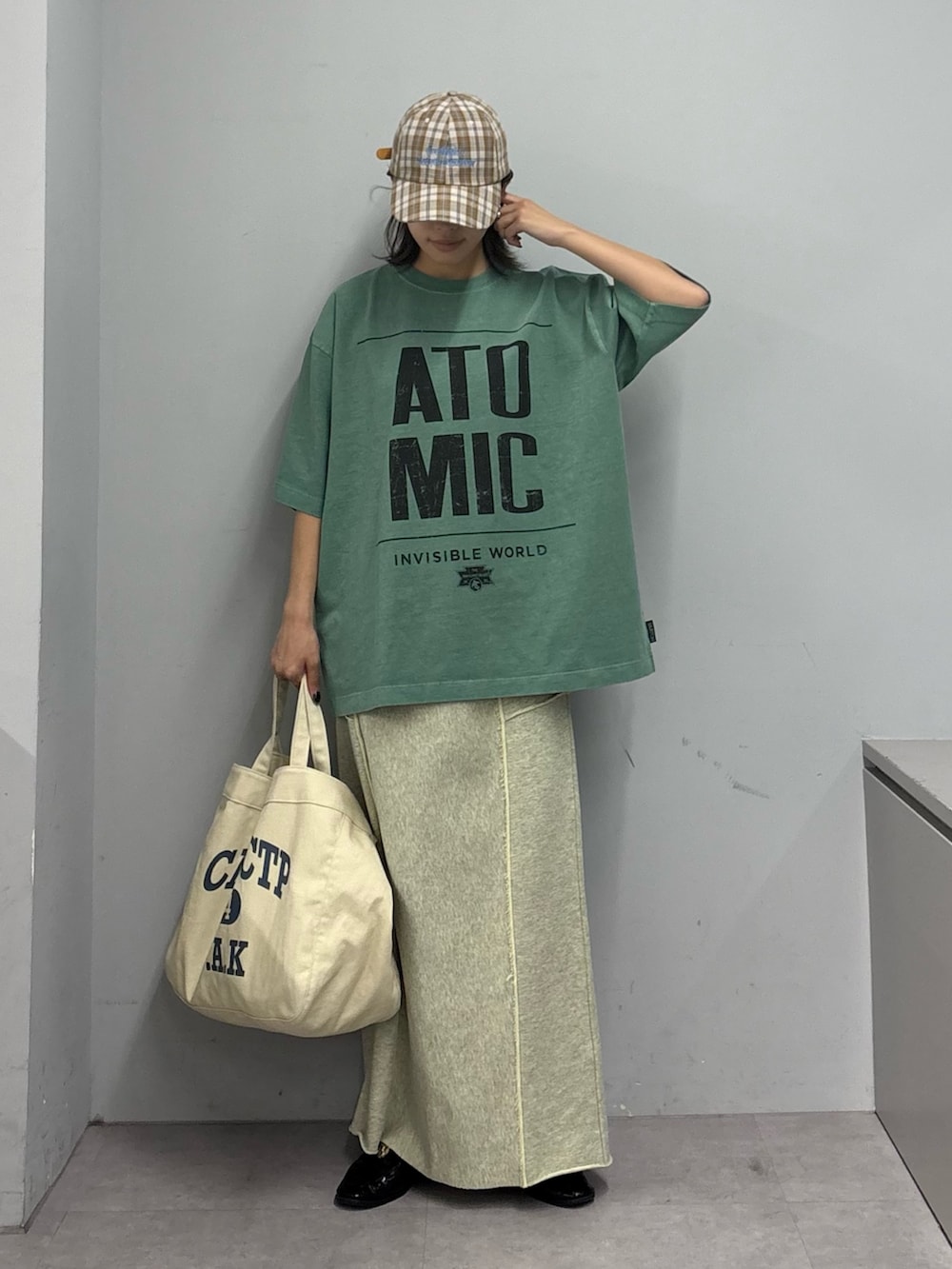 グリーン系のTシャツ/カットソー、イエロー系のスカート、ホワイト系のショルダーバッグを着用したレディースの春コーディネートの2枚目の写真
