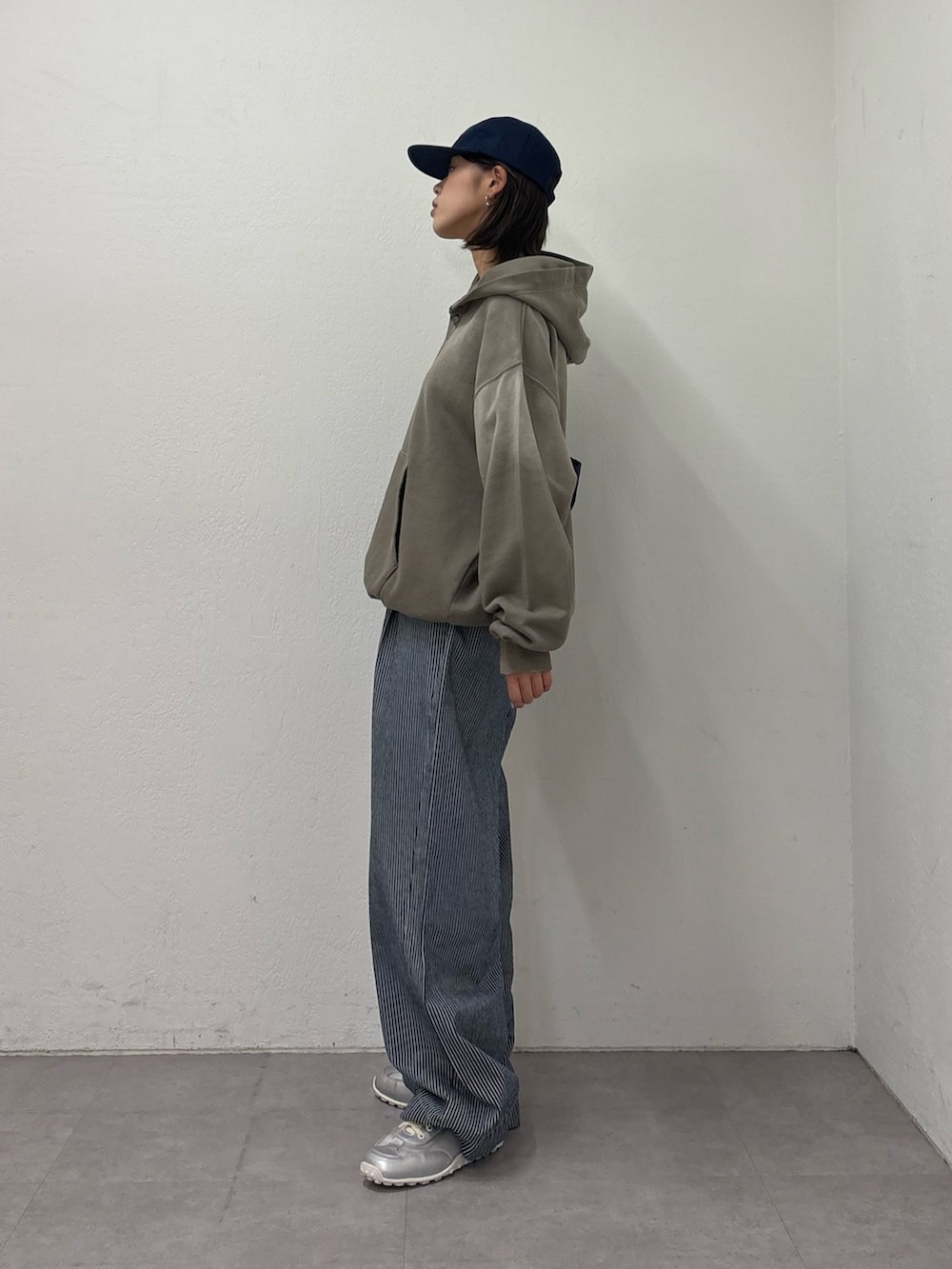 ブルー系のデニムパンツ、シルバー系のスニーカー、ベージュ系のパーカーを着用したレディースの冬コーディネートの2枚目の写真