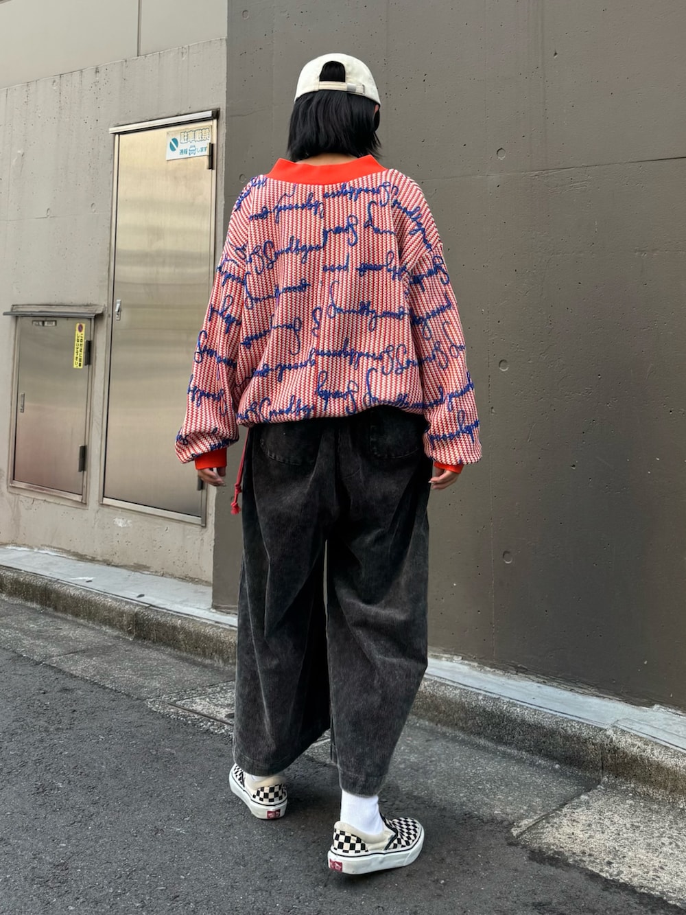 オレンジ系のニット/セーター、ブラック系のその他パンツ、ベージュ系のハットを着用したレディースの秋コーディネートの3枚目の写真