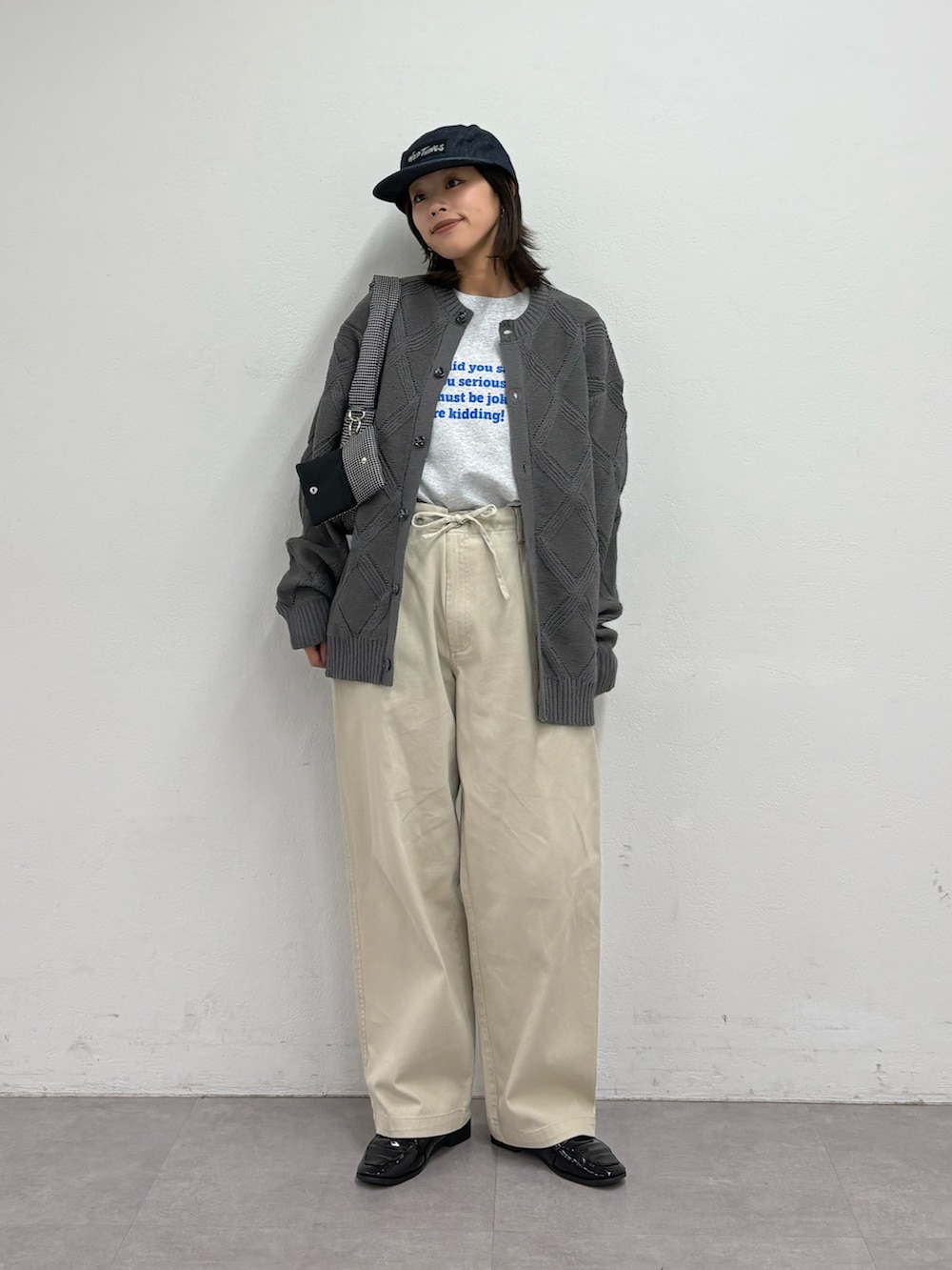 グレー系のカーディガン/ボレロ、グレー系のTシャツ/カットソー、ホワイト系のチノパンツを着用したレディースの春コーディネートの2枚目の写真