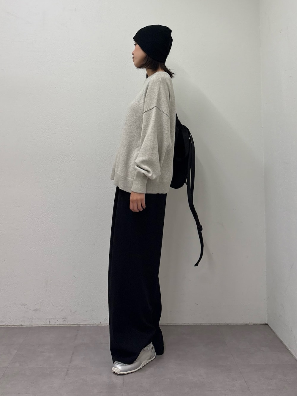 ホワイト系のニット/セーター、ブラック系のスラックス、シルバー系のスニーカーを着用したレディースの冬コーディネートの2枚目の写真