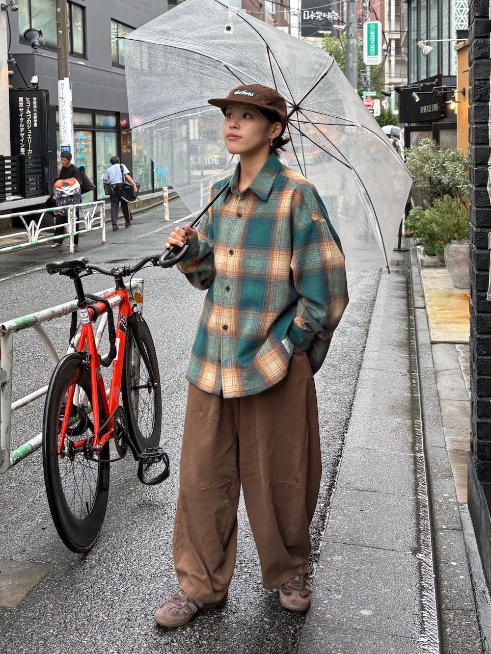 オレンジ系のシャツ/ブラウス、ブラウン系のデニムパンツを着用したレディースの秋コーディネートの2枚目の写真