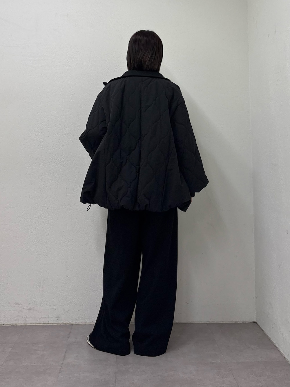 ブラック系のブルゾン、ホワイト系のTシャツ/カットソー、ブラック系のスラックスを着用したレディースの冬コーディネートの3枚目の写真