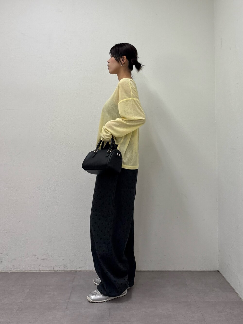 イエロー系のTシャツ/カットソー、ブラック系のショルダーバッグ、グレー系のその他パンツを着用したレディースの冬コーディネートの3枚目の写真