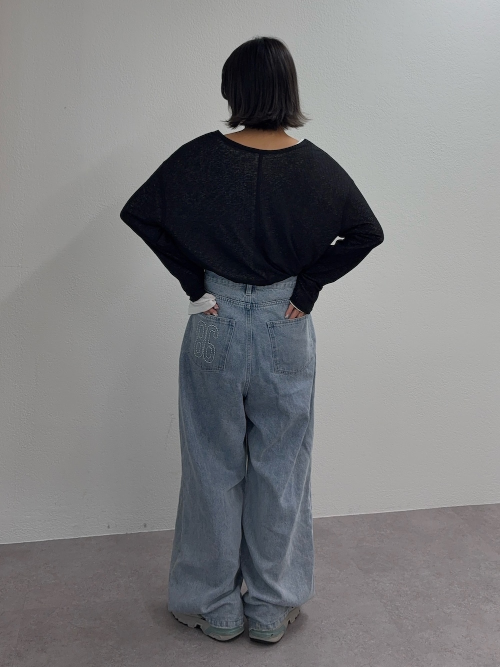 ホワイト系のTシャツ/カットソー、ブラック系のTシャツ/カットソー、ブルー系のデニムパンツを着用したレディースの秋コーディネートの3枚目の写真