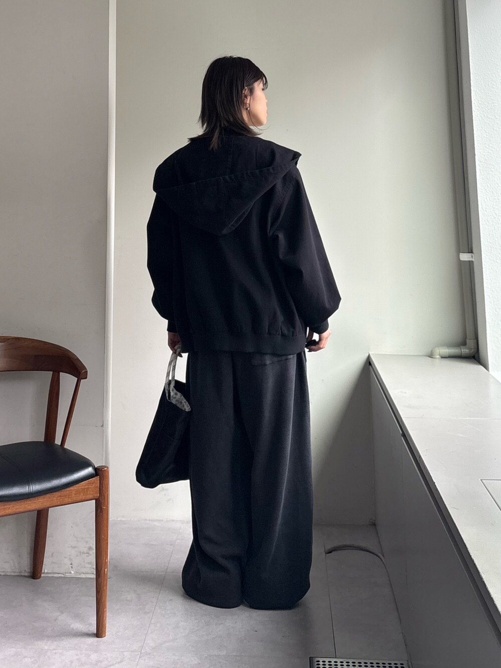 ホワイト系のTシャツ/カットソー、ブラック系のスウェットパンツ、ブラック系のショルダーバッグを着用したレディースの春コーディネートの4枚目の写真