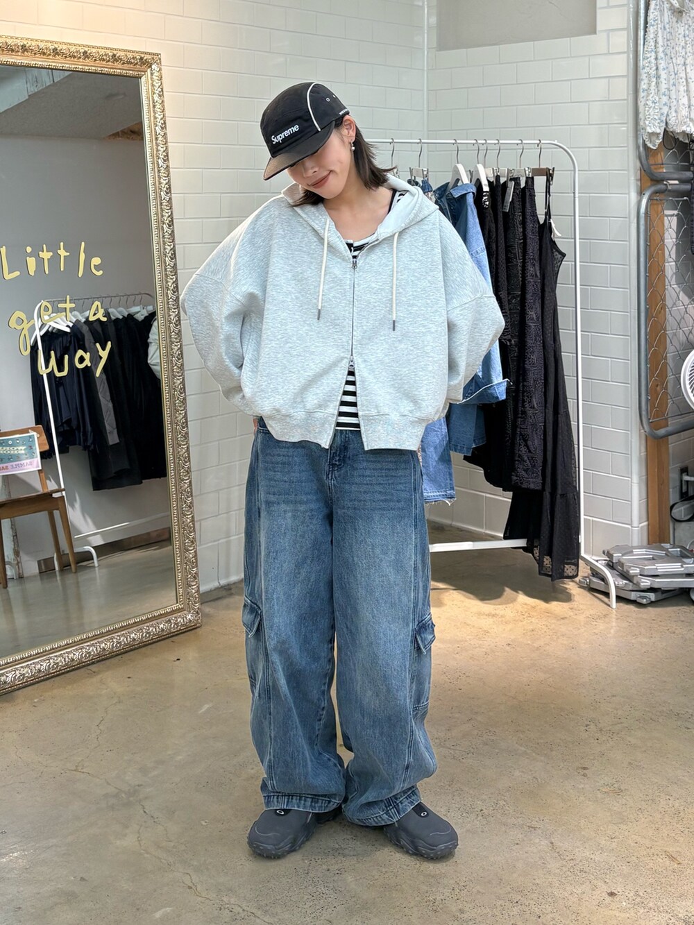 グレー系のパーカー、ブルー系のカーゴパンツを着用したレディースの春コーディネートの2枚目の写真