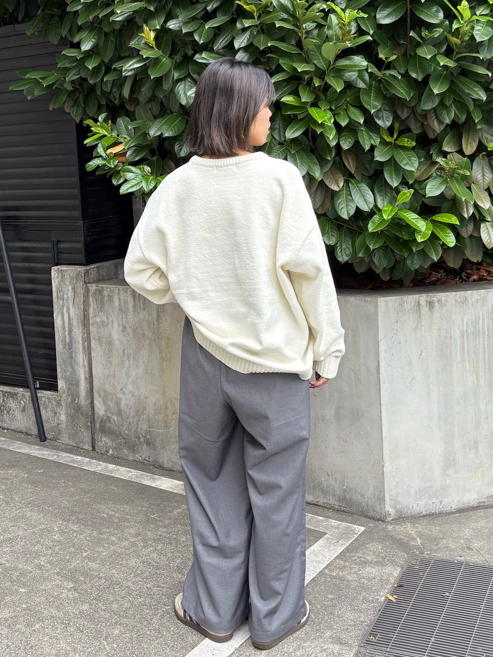 ホワイト系のニット/セーター、グレー系のスラックスを着用したレディースの秋コーディネートの3枚目の写真