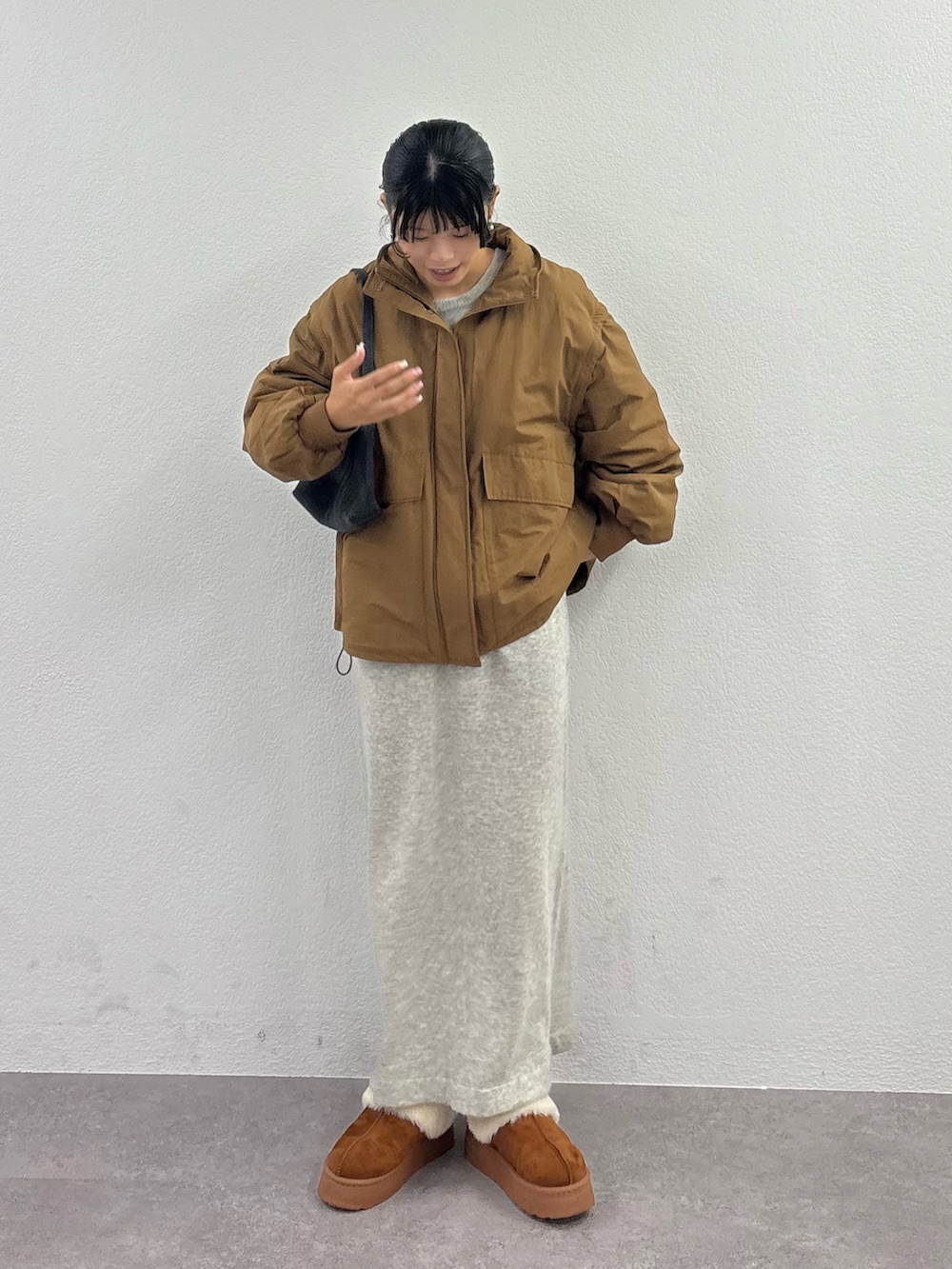 ブラウン系のブルゾン、ブラウン系のサンダル、イエロー系のハンドバッグを着用したレディースの秋コーディネートの2枚目の写真