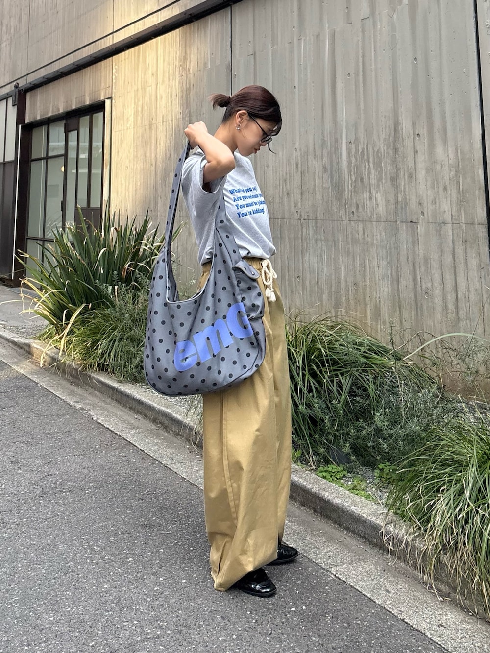 グレー系のTシャツ/カットソー、ベージュ系のチノパンツ、グレー系のショルダーバッグを着用したレディースの春コーディネートの2枚目の写真