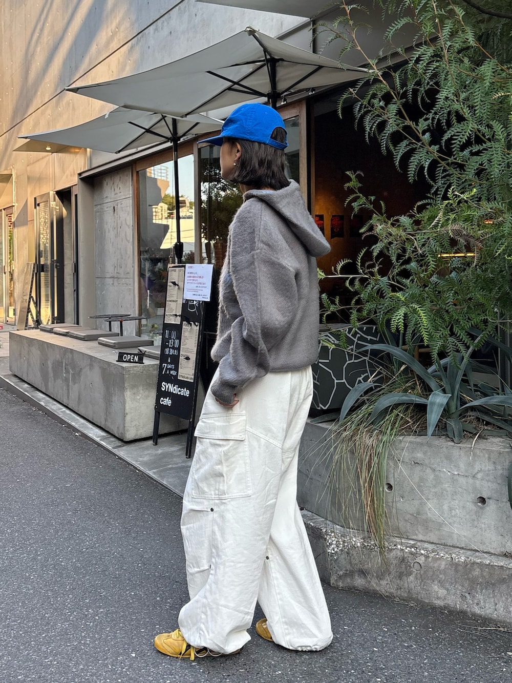 グレー系のパーカー、ホワイト系のその他パンツを着用したレディースの秋コーディネートの2枚目の写真