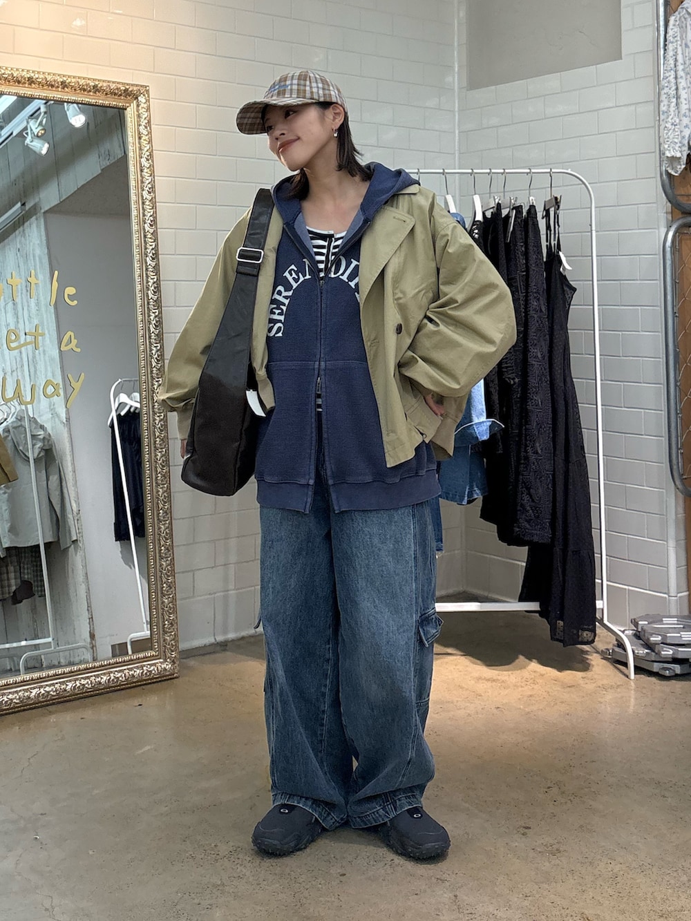 ベージュ系のトレンチコート、ブルー系のカーゴパンツ、ベージュ系のハットを着用したレディースの春コーディネートの3枚目の写真