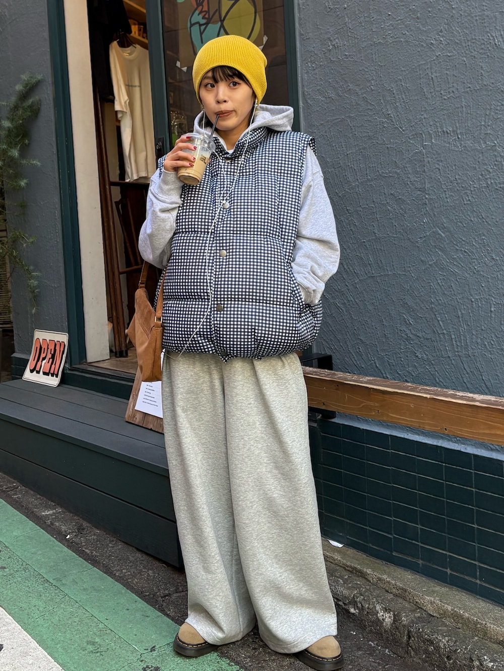 グレー系のパーカー、ブルー系のベスト、グレー系のその他パンツを着用したレディースの秋コーディネートの4枚目の写真
