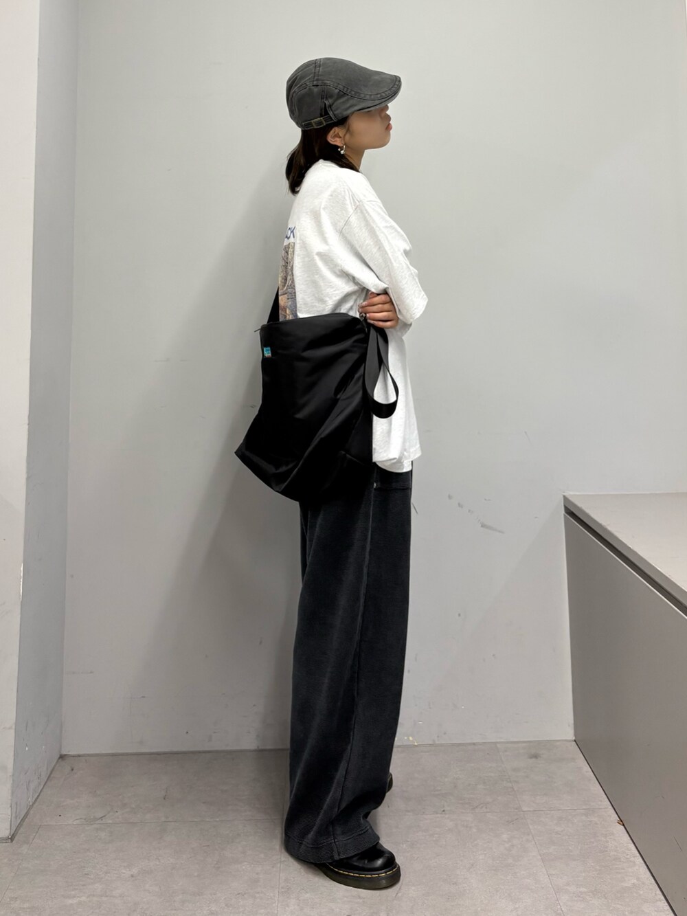 グレー系のTシャツ/カットソー、ブラック系のショルダーバッグ、ブラック系のスウェットパンツを着用したレディースの春コーディネートの2枚目の写真