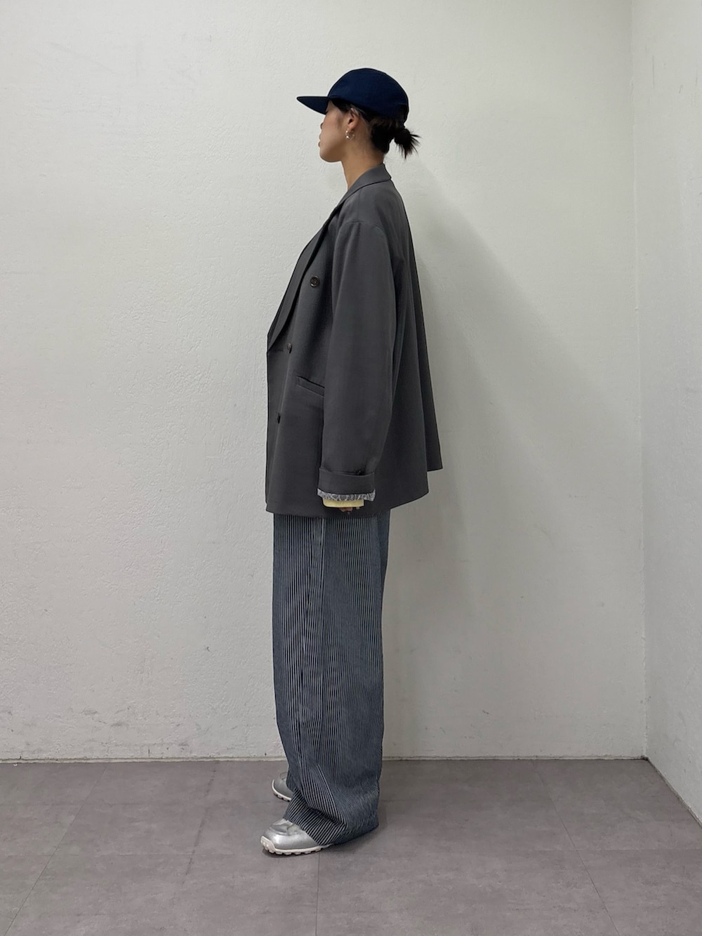 グレー系のテーラードジャケット、イエロー系のTシャツ/カットソー、ブルー系のデニムパンツを着用したレディースの冬コーディネートの3枚目の写真