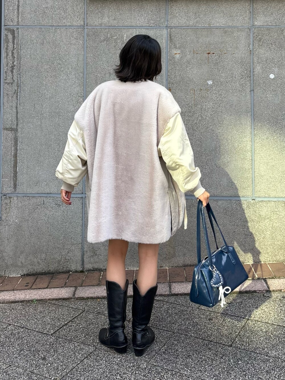 ブラウン系のTシャツ/カットソー、ホワイト系のミリタリージャケット、ブルー系のトートバッグを着用したレディースの秋コーディネートの3枚目の写真