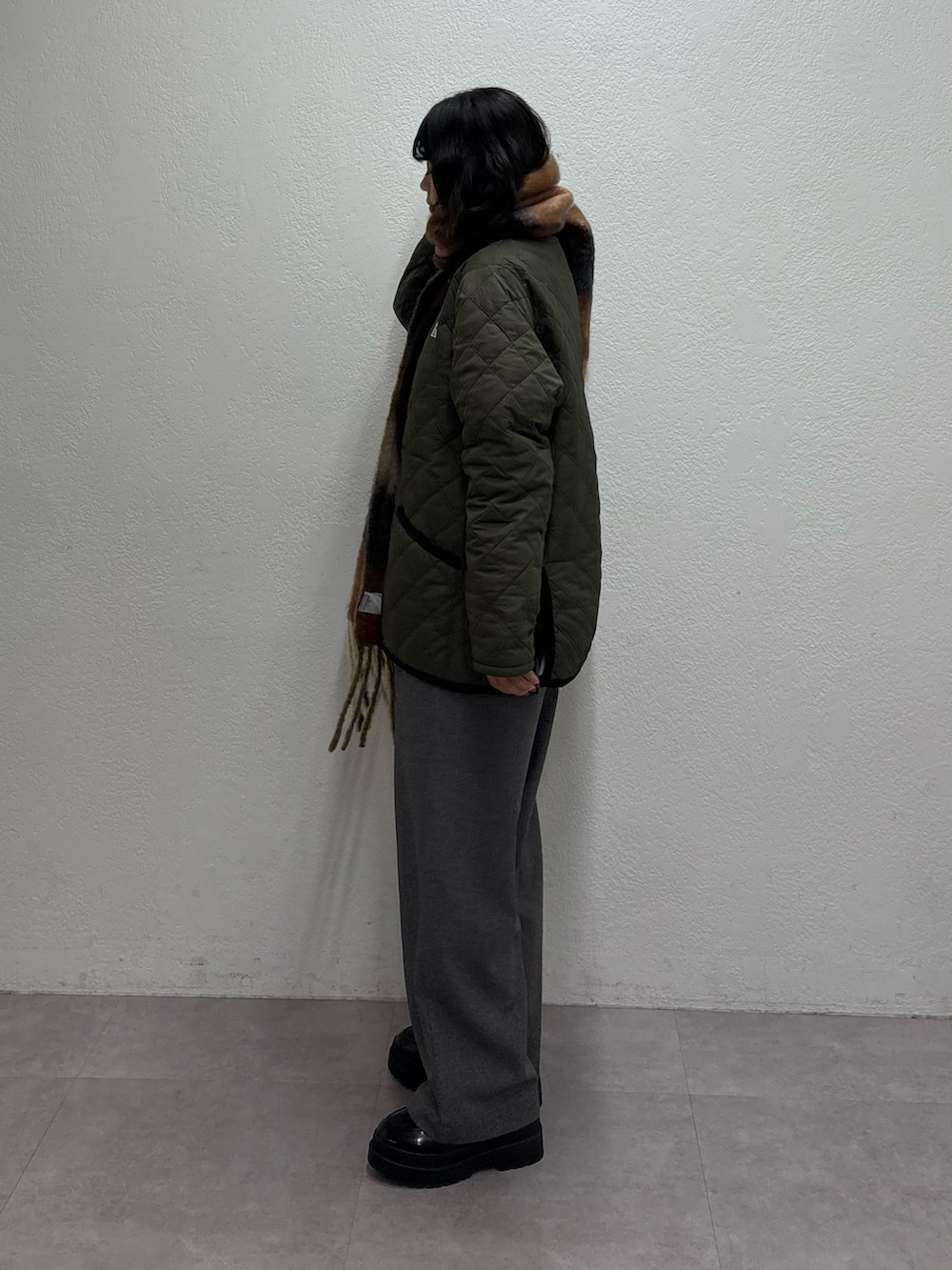 グリーン系のブルゾン、グレー系のスウェット、グレー系のスラックスを着用したレディースの秋コーディネートの2枚目の写真