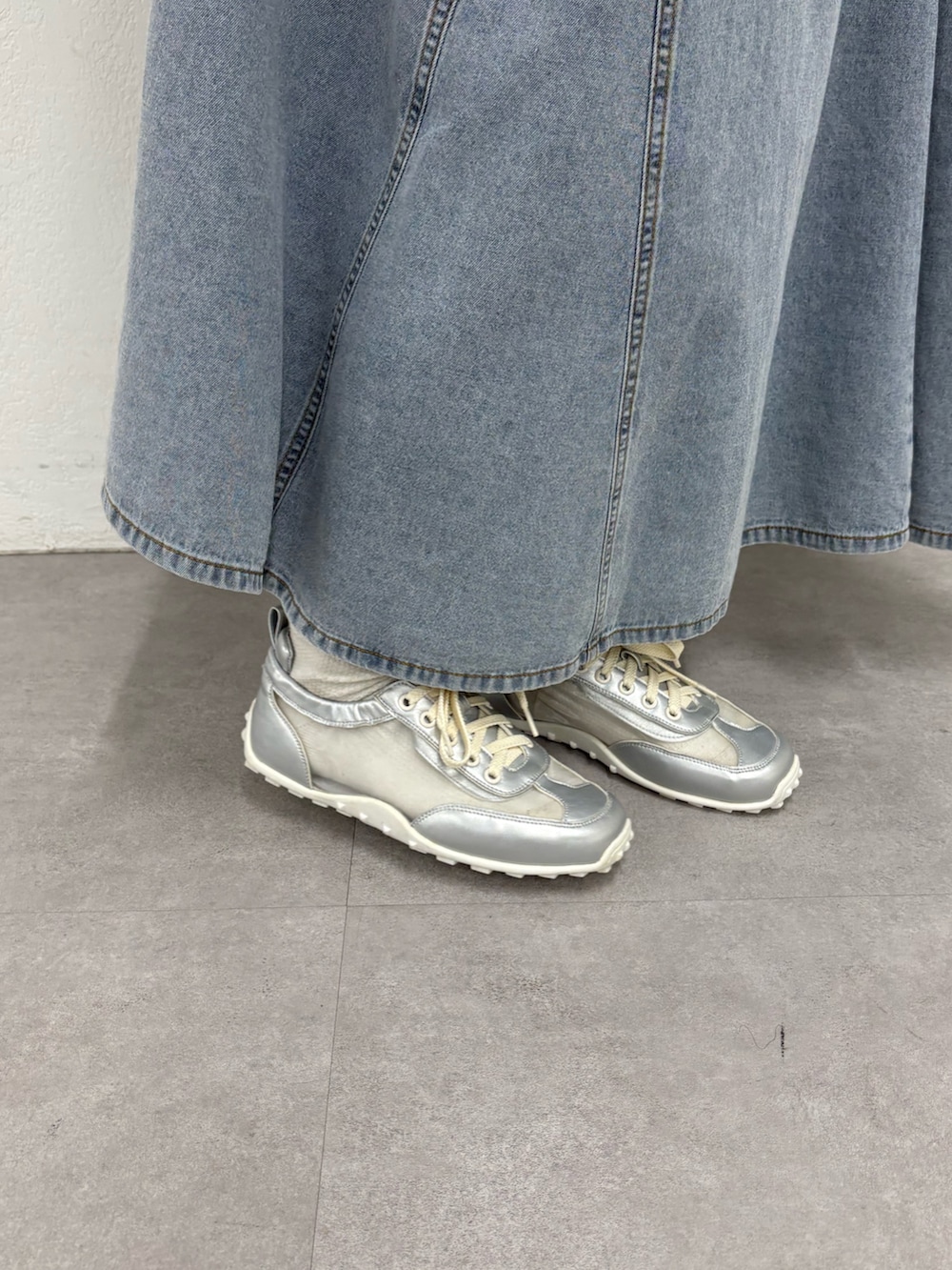 グレー系のTシャツ/カットソー、ホワイト系のトートバッグ、ブルー系のスカートを着用したレディースの春コーディネートの4枚目の写真