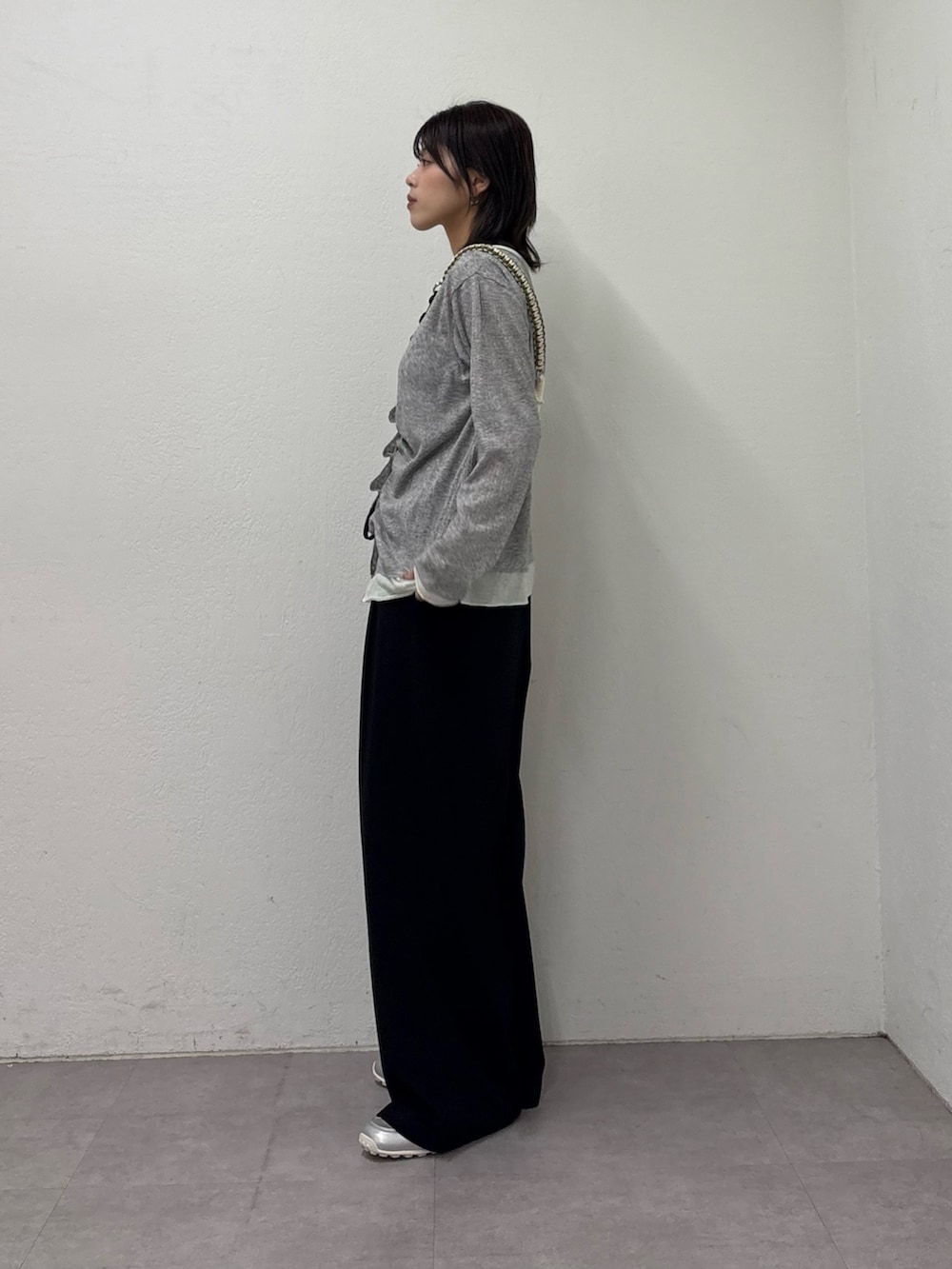 グレー系のTシャツ/カットソー、ブラック系のスラックス、シルバー系のスニーカーを着用したレディースの冬コーディネートの2枚目の写真