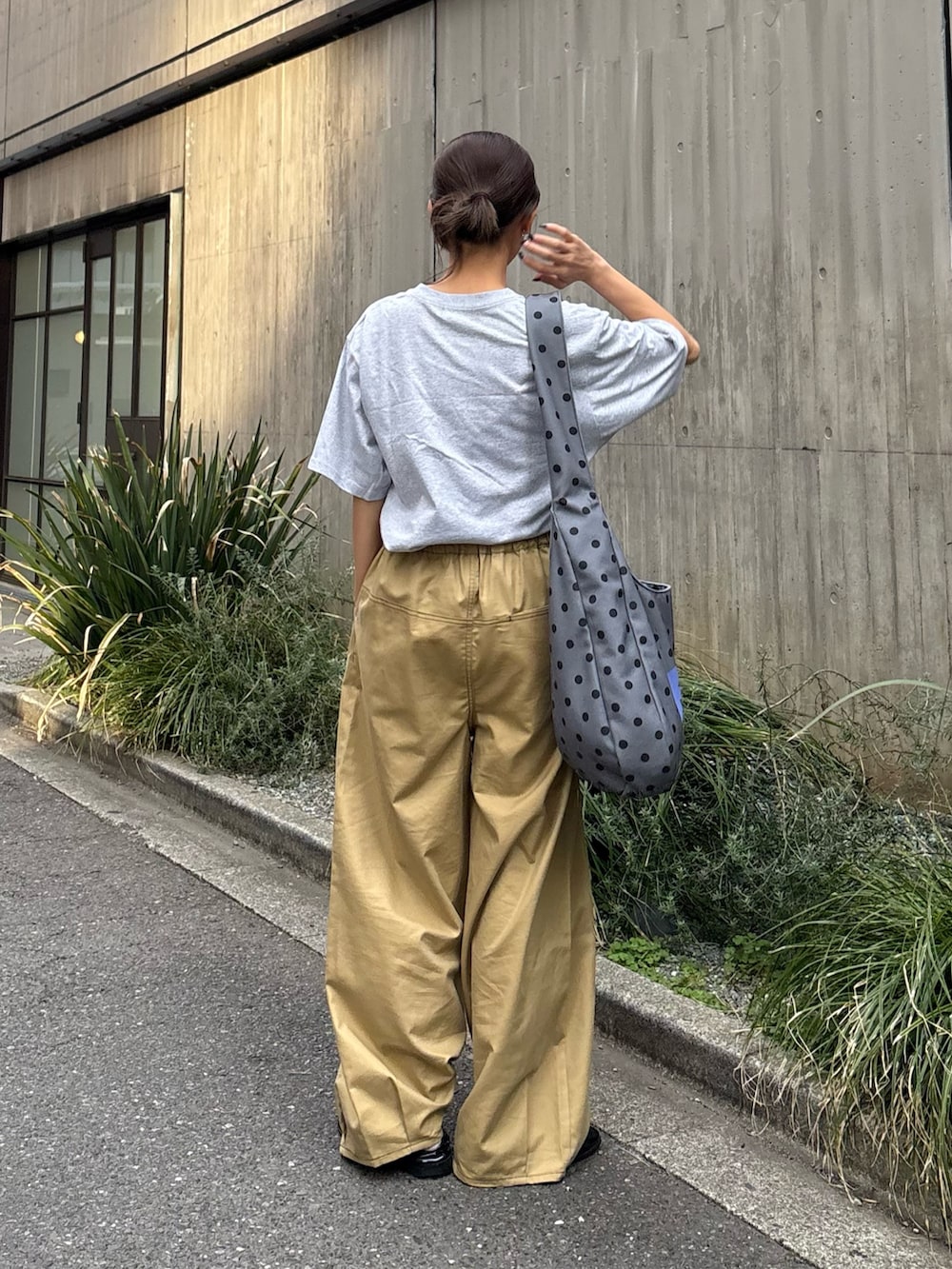 グレー系のTシャツ/カットソー、ベージュ系のチノパンツ、グレー系のショルダーバッグを着用したレディースの春コーディネートの3枚目の写真
