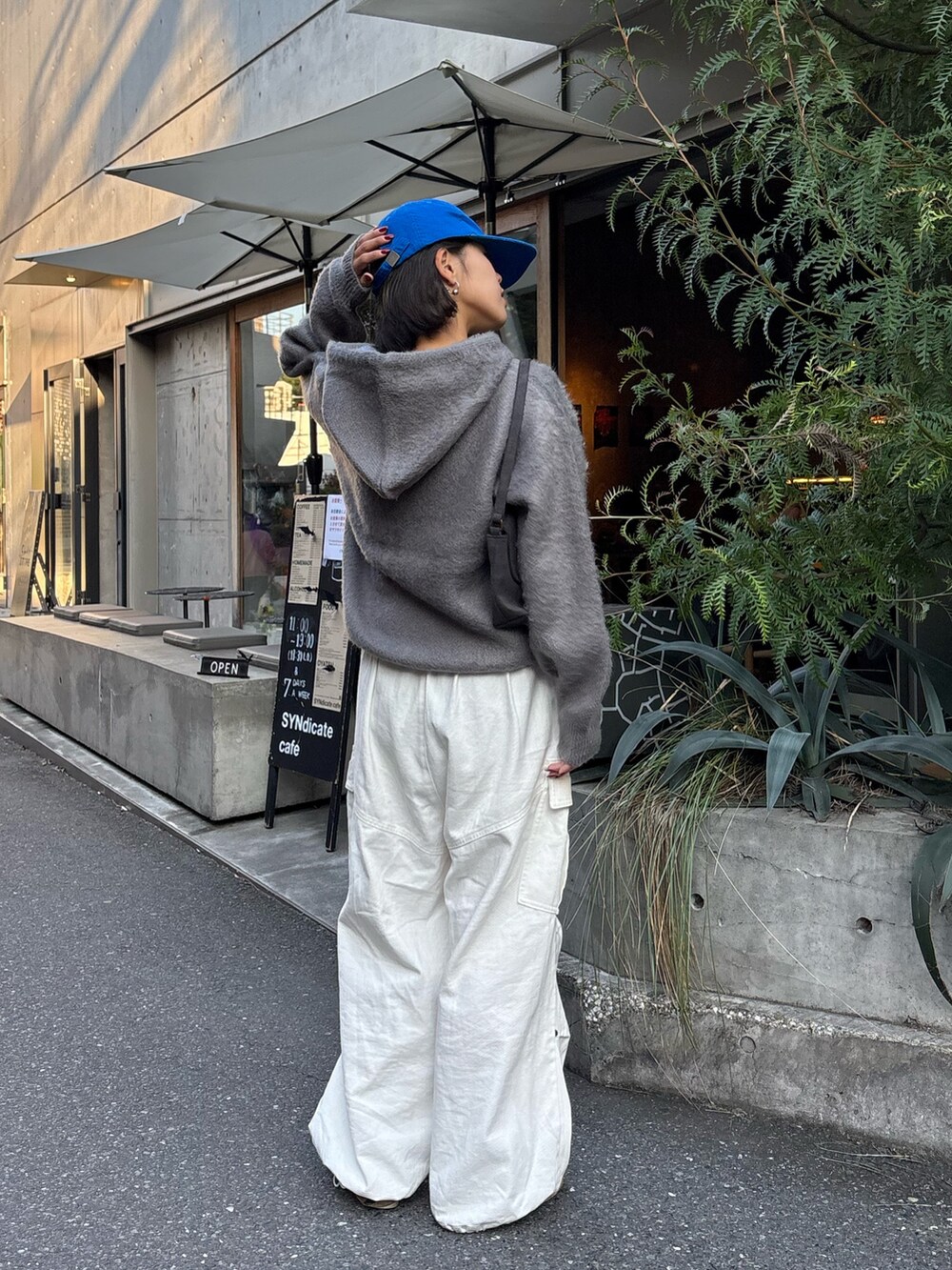 グレー系のパーカー、ホワイト系のその他パンツを着用したレディースの秋コーディネートの3枚目の写真