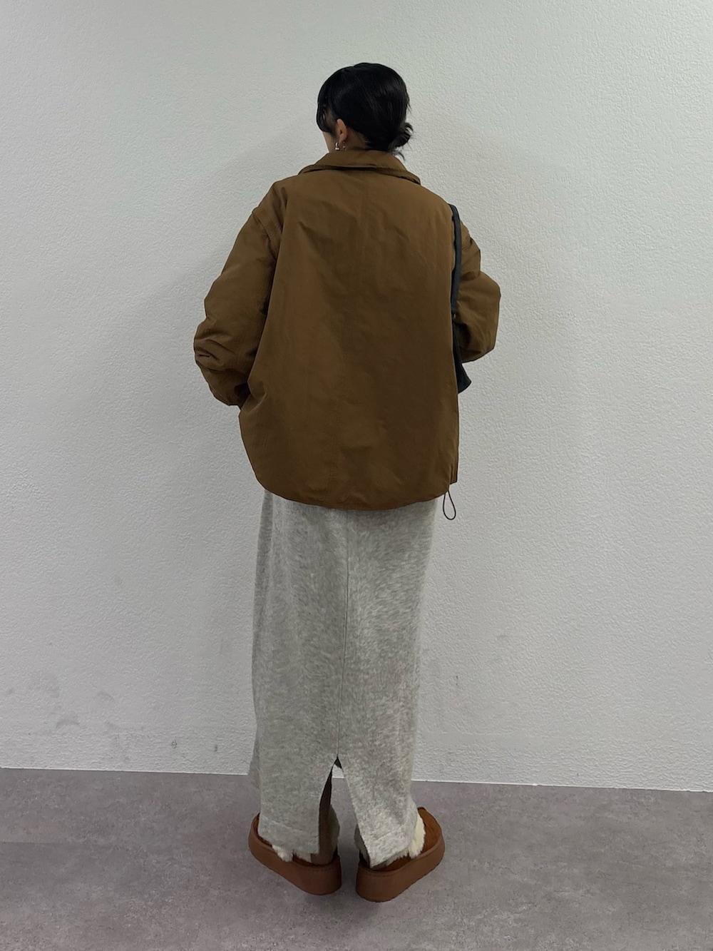 ブラウン系のブルゾン、ブラウン系のサンダル、イエロー系のハンドバッグを着用したレディースの秋コーディネートの4枚目の写真