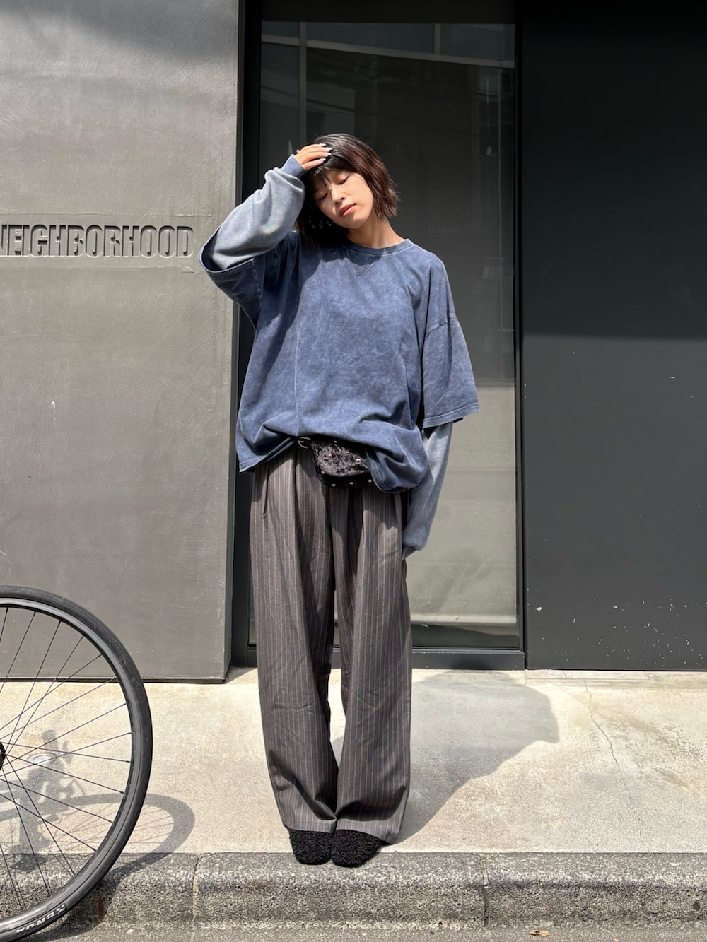 ブルー系のTシャツ/カットソー、グレー系のスラックス、ブラック系のボディバッグ/ウエストポーチを着用したレディースの秋コーディネートの3枚目の写真