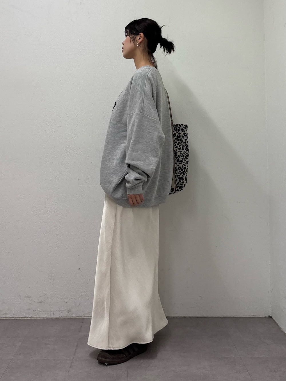 グレー系のスウェット、ホワイト系のスカート、ホワイト系のトートバッグを着用したレディースの冬コーディネートの2枚目の写真