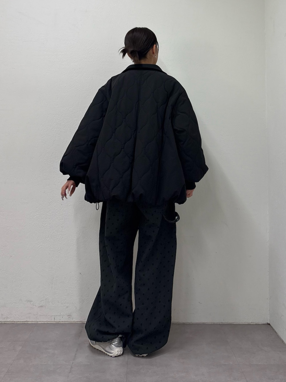 ブラック系のブルゾン、ホワイト系のニット/セーター、グレー系のその他パンツを着用したレディースの冬コーディネートの4枚目の写真