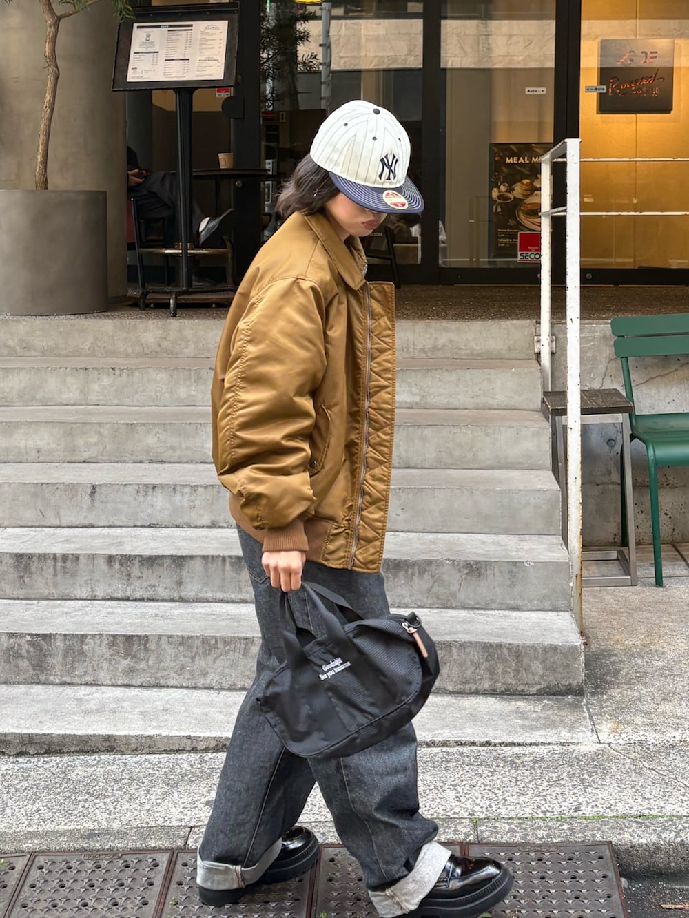 イエロー系のMA-1、ブラック系のトートバッグを着用したレディースの秋コーディネートの4枚目の写真