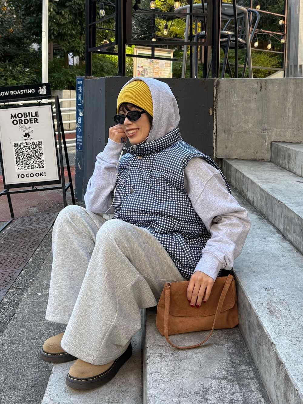 グレー系のパーカー、ブルー系のベスト、グレー系のその他パンツを着用したレディースの秋コーディネートの2枚目の写真