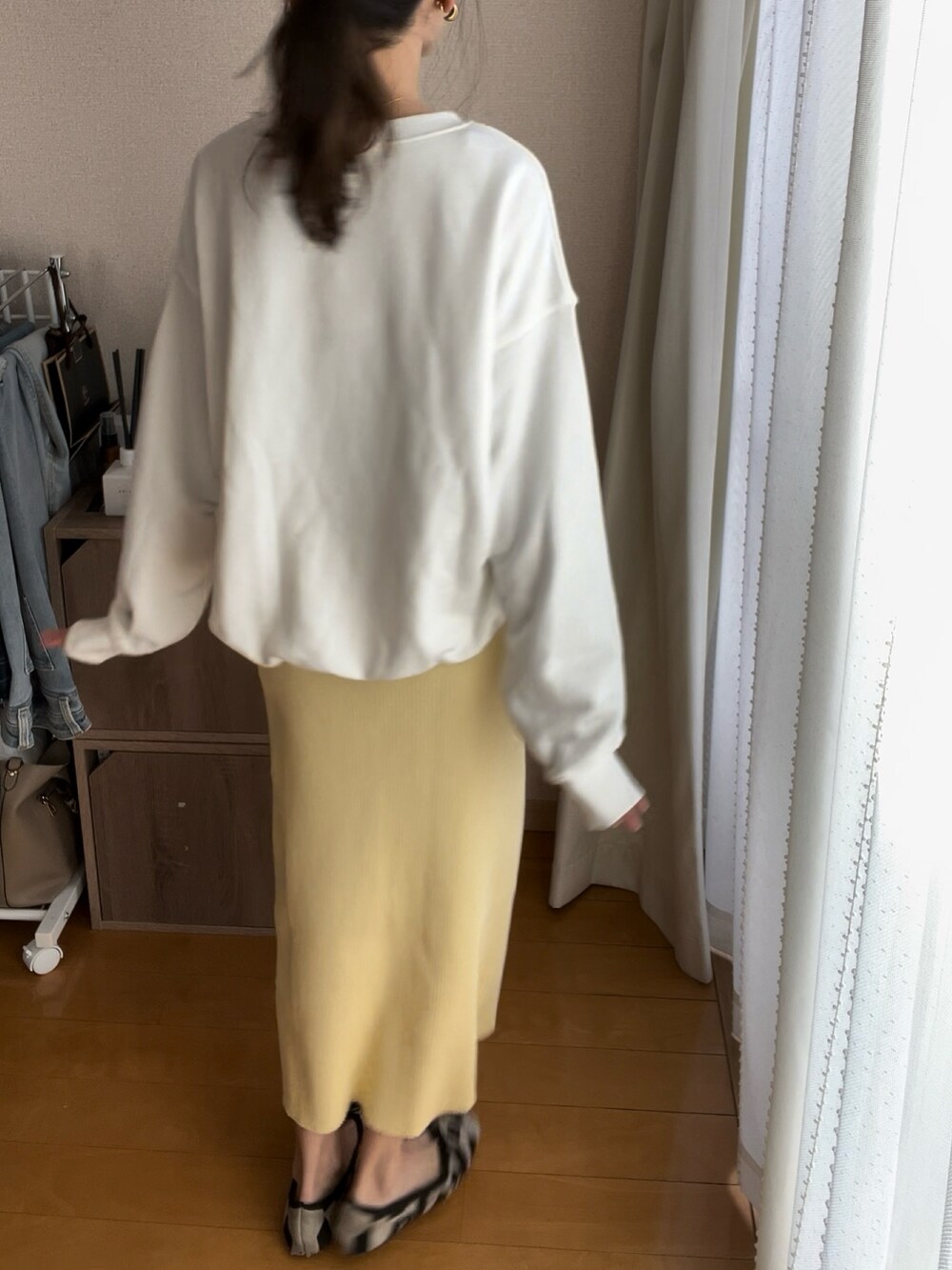 ホワイト系のスウェット、イエロー系のスカート、その他のパンプスを着用したレディースの春コーディネートの2枚目の写真