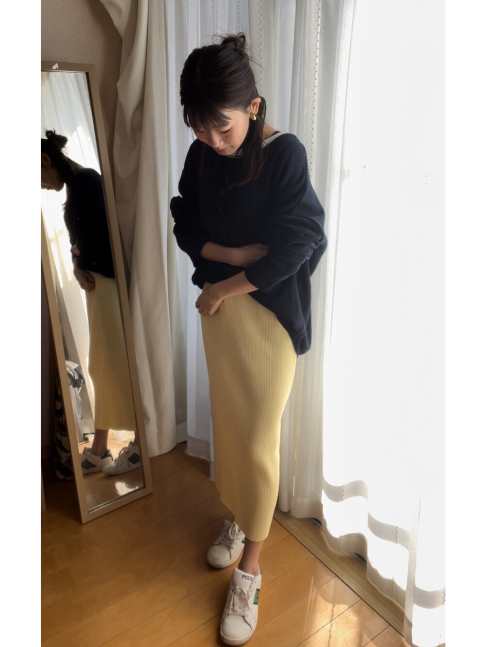 ホワイト系のスニーカー、イエロー系のスカート、その他のニット/セーターを着用したレディースの春コーディネートの2枚目の写真