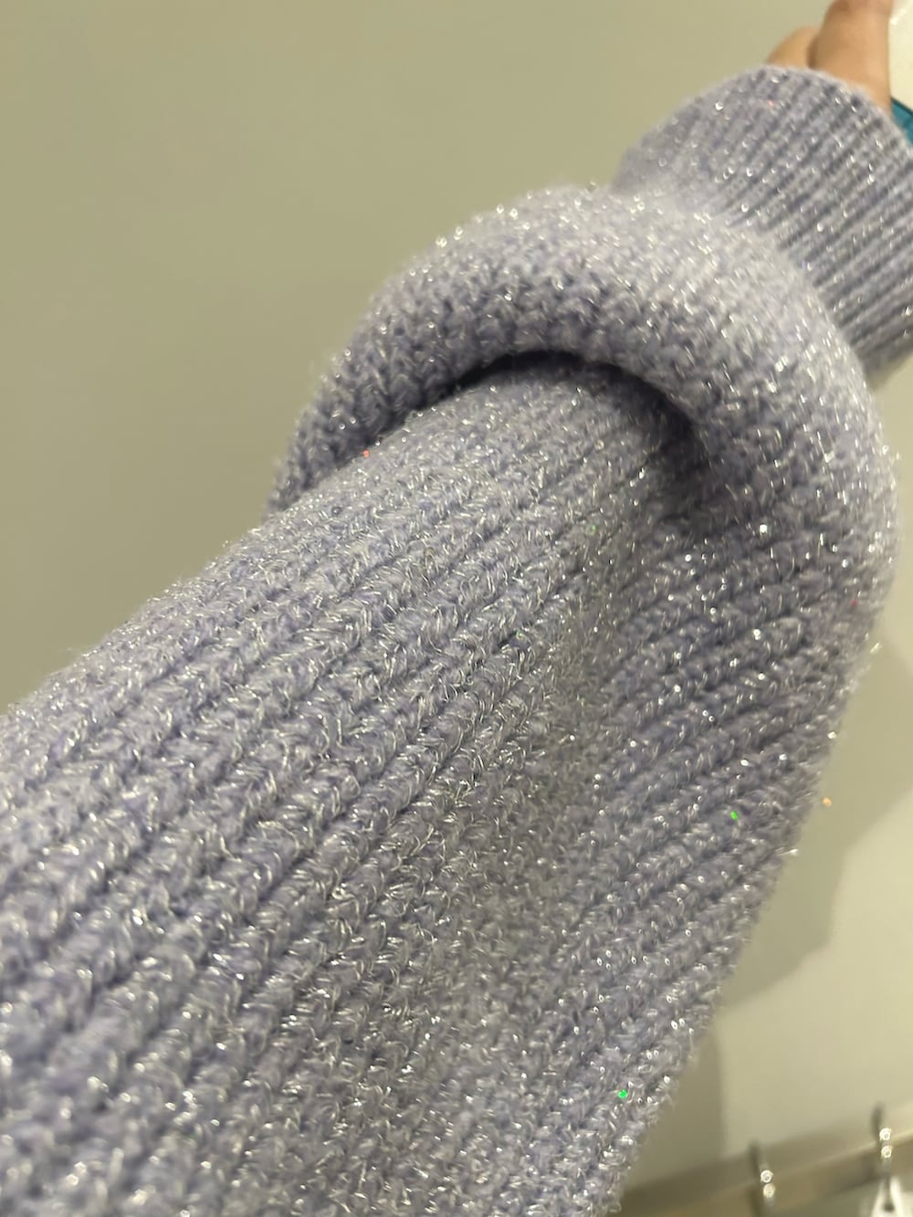 パープル系のニット/セーター、パープル系のスカート、ホワイト系のブーツを着用したレディースの秋コーディネートの4枚目の写真