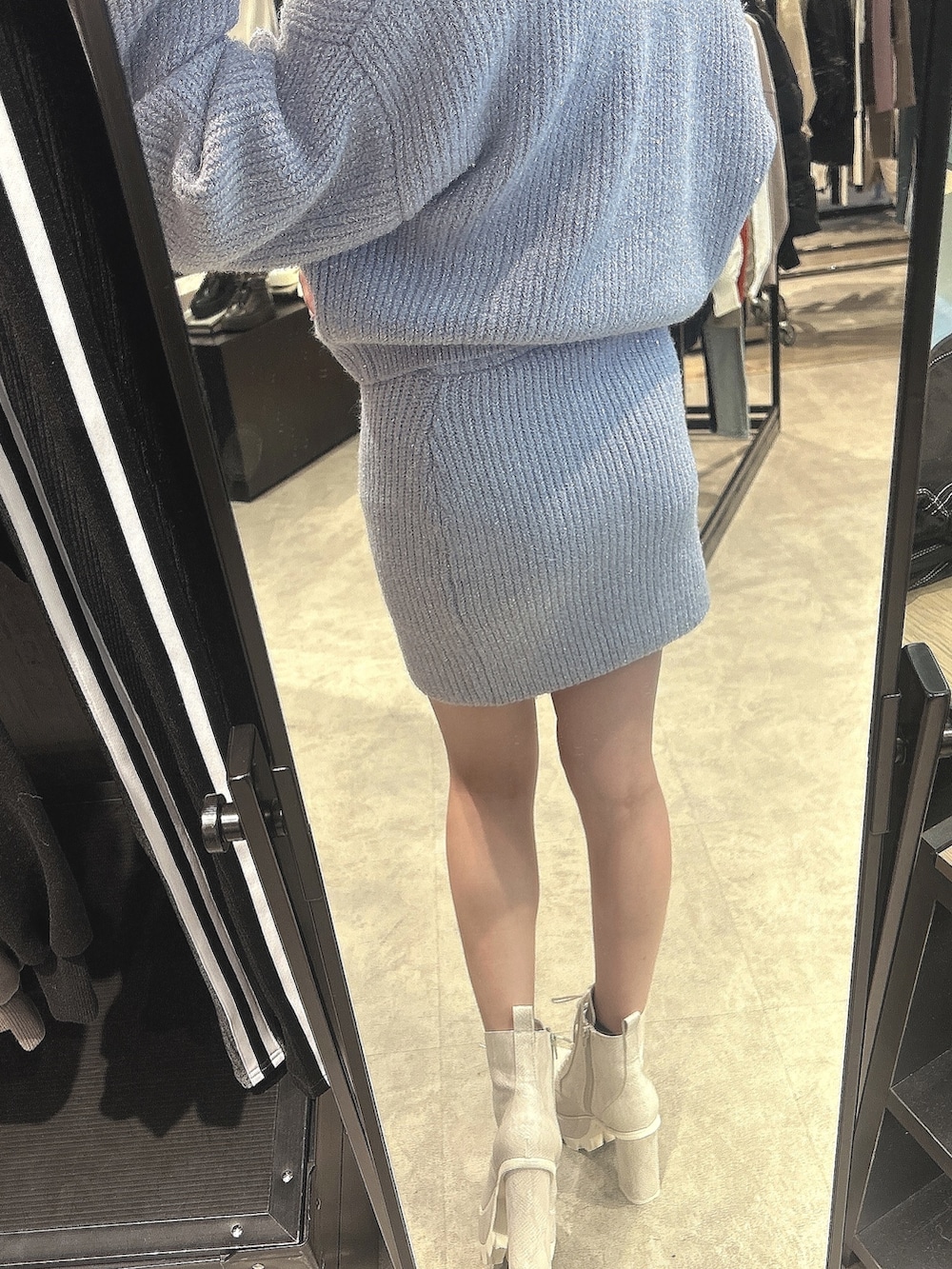 パープル系のニット/セーター、パープル系のスカート、ホワイト系のブーツを着用したレディースの秋コーディネートの3枚目の写真