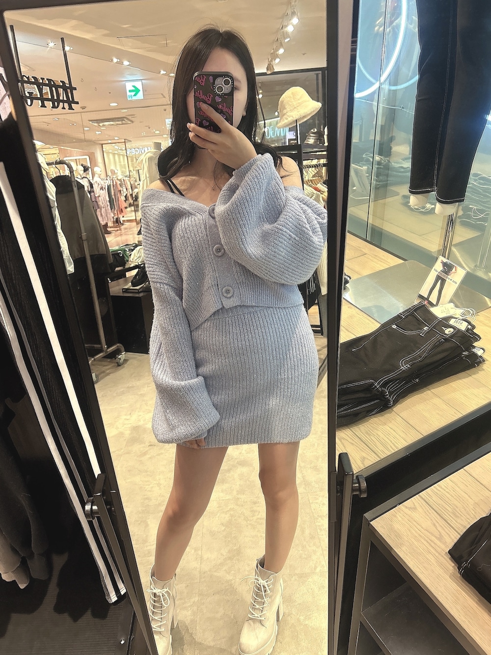 パープル系のニット/セーター、パープル系のスカート、ホワイト系のブーツを着用したレディースの秋コーディネートの2枚目の写真