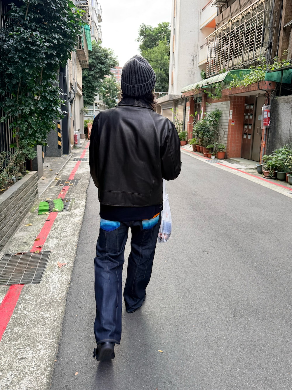 ブラック系のライダースジャケット、ブラック系のデニムパンツ、ブラック系のスリッポンを着用したメンズの冬コーディネートの3枚目の写真