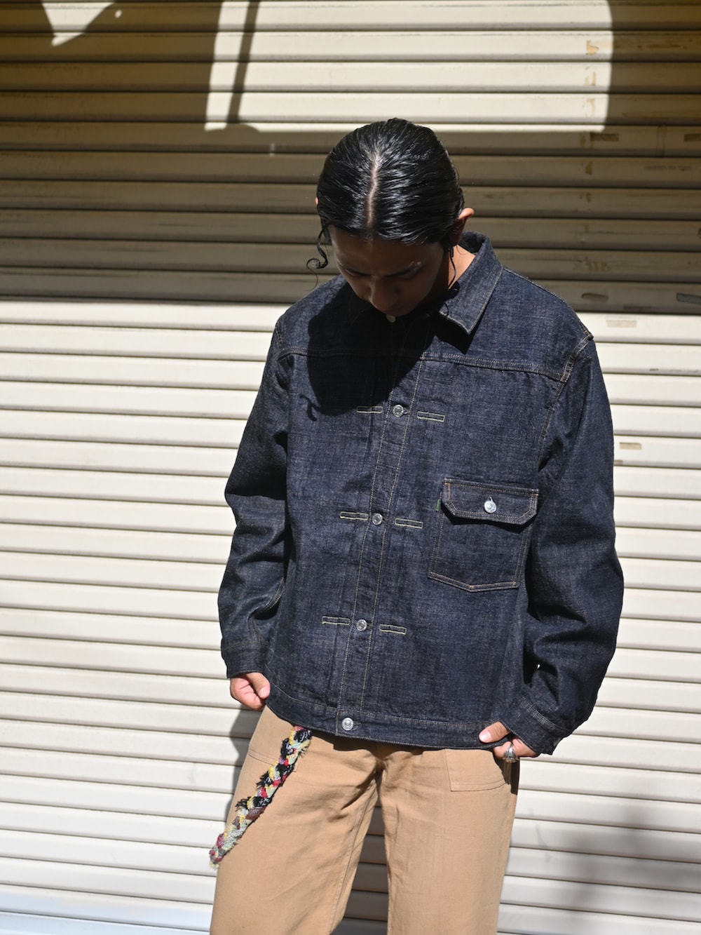 ブルー系のデニムジャケット、ベージュ系のその他パンツ、グリーン系のスニーカーを着用したメンズの秋コーディネートの2枚目の写真