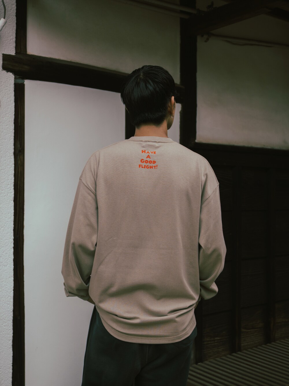 ベージュ系のトップス、ブラック系のスウェットパンツ、ブラック系のスリッポンを着用したメンズの秋コーディネートの3枚目の写真