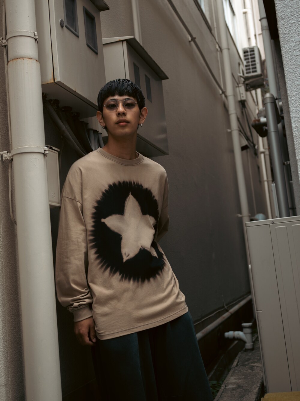 ベージュ系のトップス、ブラック系のスウェットパンツ、ブラック系のスリッポンを着用したメンズの秋コーディネートの2枚目の写真