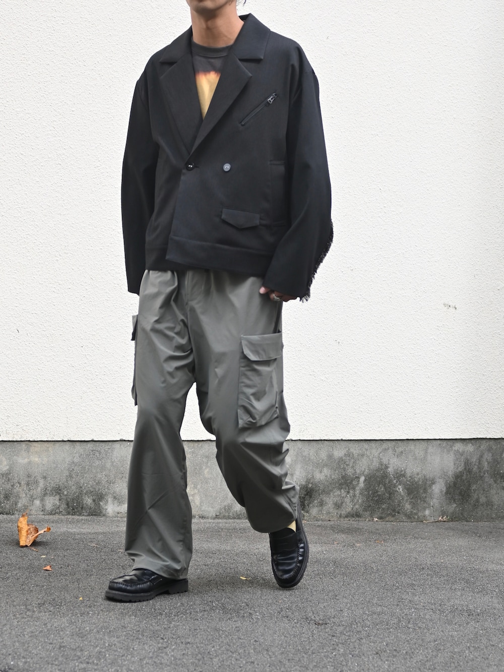ブラック系のテーラードジャケット、グレー系のカーゴパンツ、ブラック系のローファーを着用したメンズの秋コーディネートの2枚目の写真