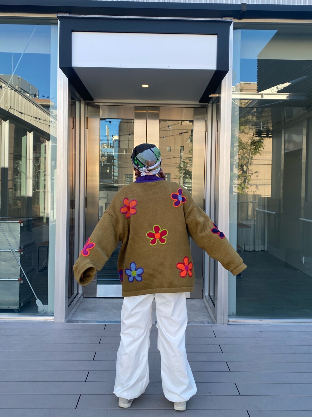 ホワイト系のカーゴパンツ、ブラウン系のニット/セーター、ホワイト系のスニーカーを着用したレディースの春コーディネートの2枚目の写真